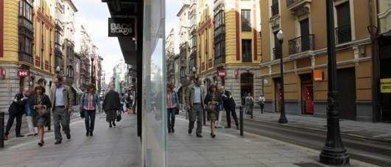 Paseantes por una zona comercial de Gijón.