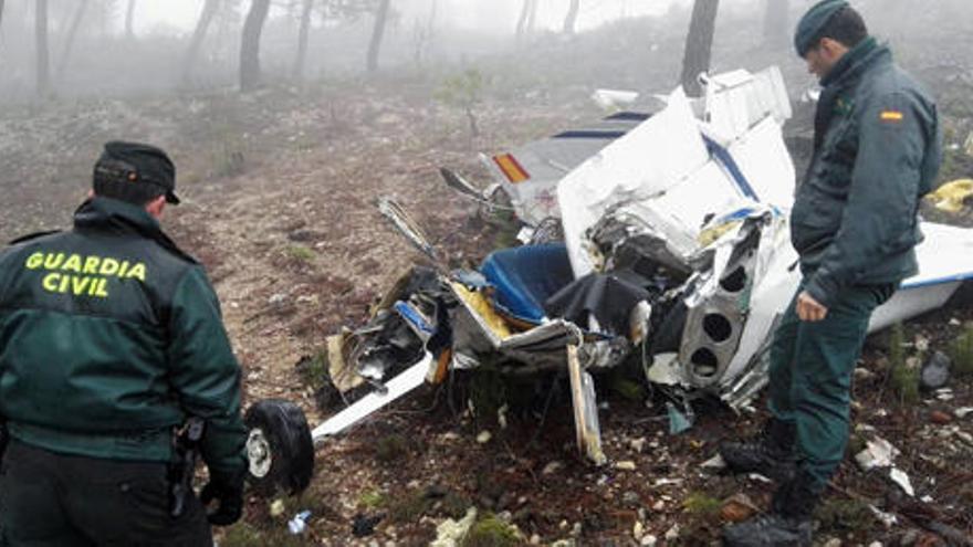 Dos agentes custodian los restos de la Cessna 172, hallada en un paraje de difícil acceso.