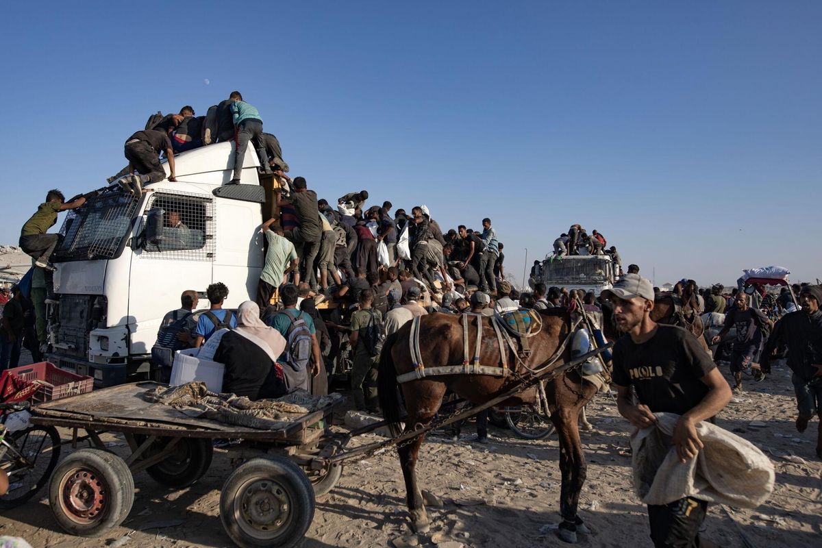 GAZA (---), 04/08/2025.- Internally displaced Palestinians climb aid trucks to get food near a food distribution point in the Morag corridor, south of Khan Younis, in the southern Gaza Strip, 04 August 2025. EFE/EPA/HAITHAM IMAD