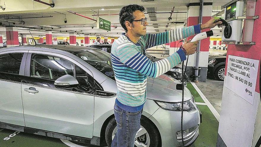 Un conductor connecta el carregador del seu cotxe en un garatge. Matías Segarra