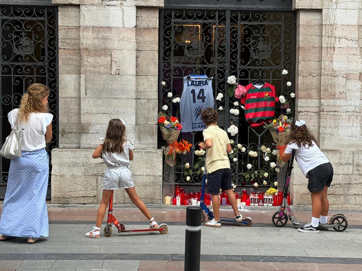 Unos niños observan el altar en menoria de Laura Cruz en las puertas del Ayuntamiento de Llanes.