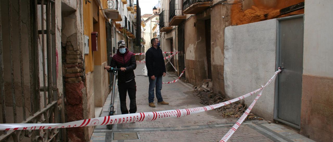 Un lorquino con un patinete cruza por la zona acordonada de Cava donde también estaba el edil del PP, este viernes. PILAR WALS