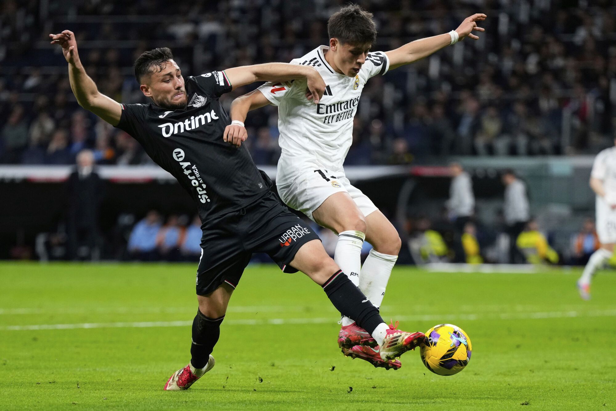 Leganes' Oscar Rodriguez, left, and Real Madrid's Arda Guler fight for the ball during a Spanish La Liga soccer match between Real Madrid and Leganes at the Santiago Bernabeu stadium in Madrid, Spain, Saturday, March 29, 2025. (AP Photo/Manu Fernandez) Associated Press/LaPresse. EDITORIAL USE ONLY/ONLY ITALY AND SPAIN