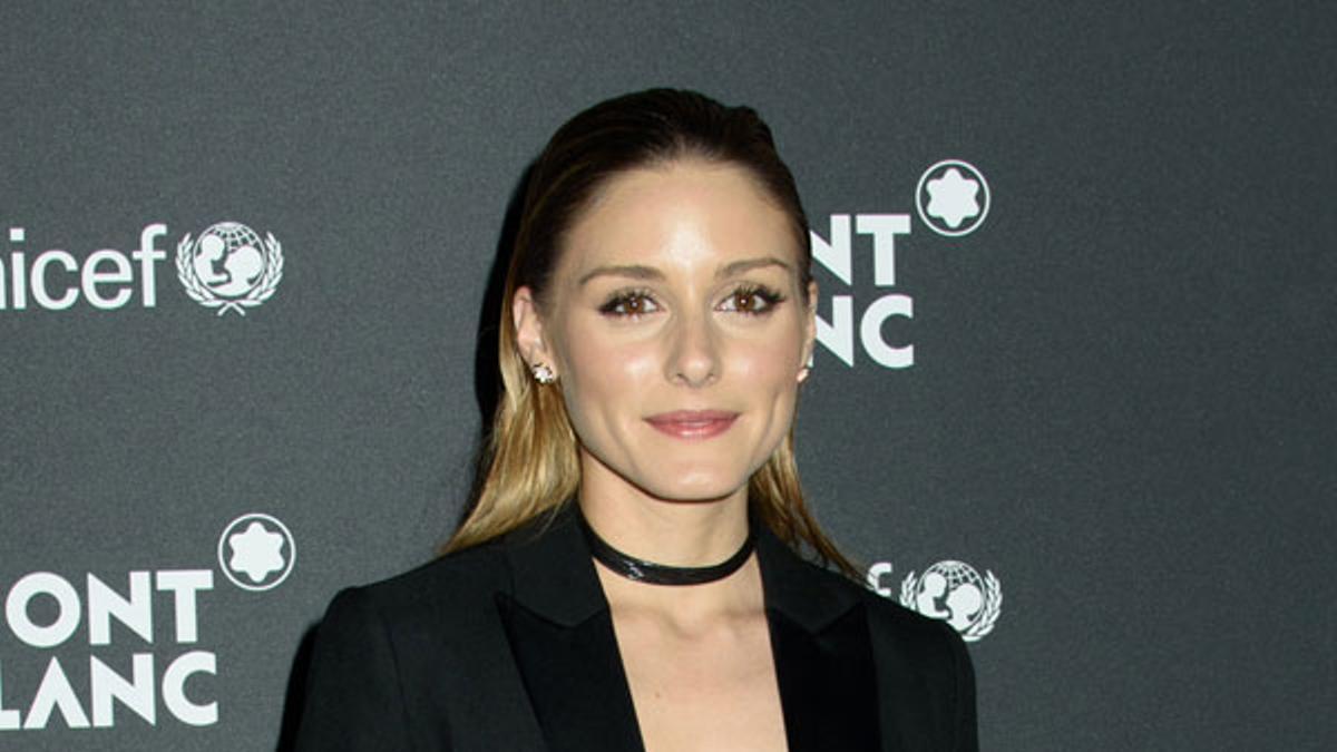 Olivia Palermo look en negro con cartera de mano de print animal