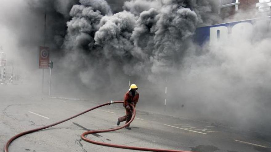 Bomberos intentan extinguir el incendio producido en un supermercado de Nairobi.