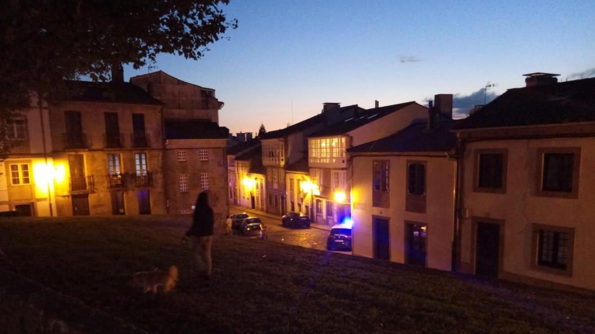 Un coche de la policía en frente de la vivienda situada en la calle Loureiros, en el casco histórico de Santiago. // FdV