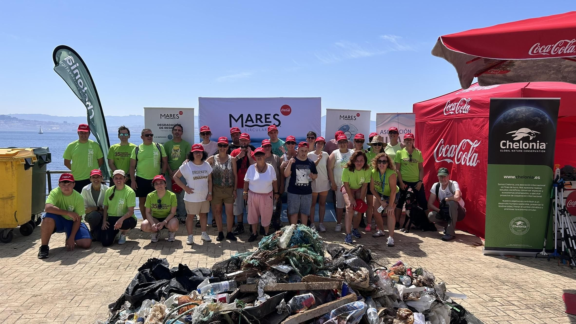Voluntarios durante la jornada de recogida de residuos en el Espigón de Massó en Cangas.