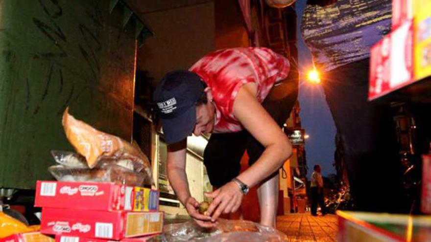 Personas buscando comida en la basura en Benidorm.