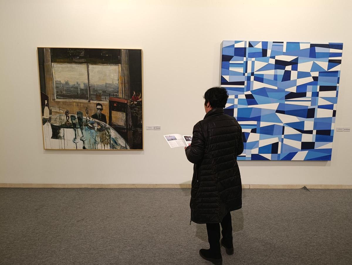 Una visitante observa dos de las obras premiadas.