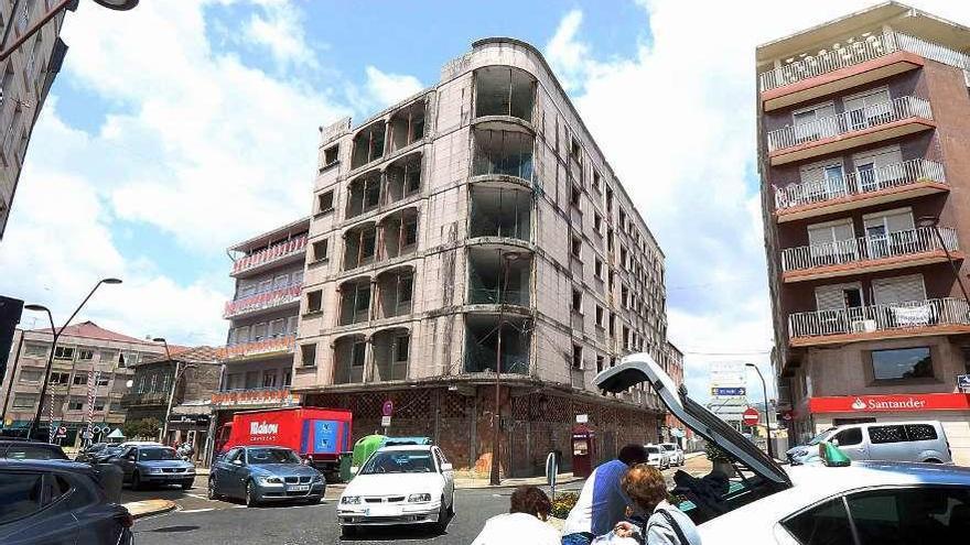 Edificio invadido por palomas (en el recuadro), junto a una parada de taxis de Porriño. // A. Hernández