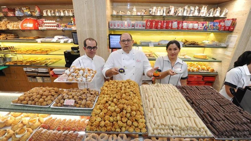 Los trabajadores de la confitería Espinosa mostraban ayer las bandejas llenas de panellets (centro), huesos de santo y buñuelos.