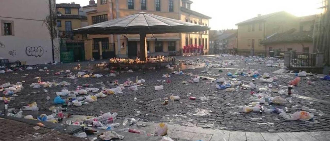 Los restos del &quot;botellón&quot;, el domingo por la mañana, en la plaza del Paraguas.