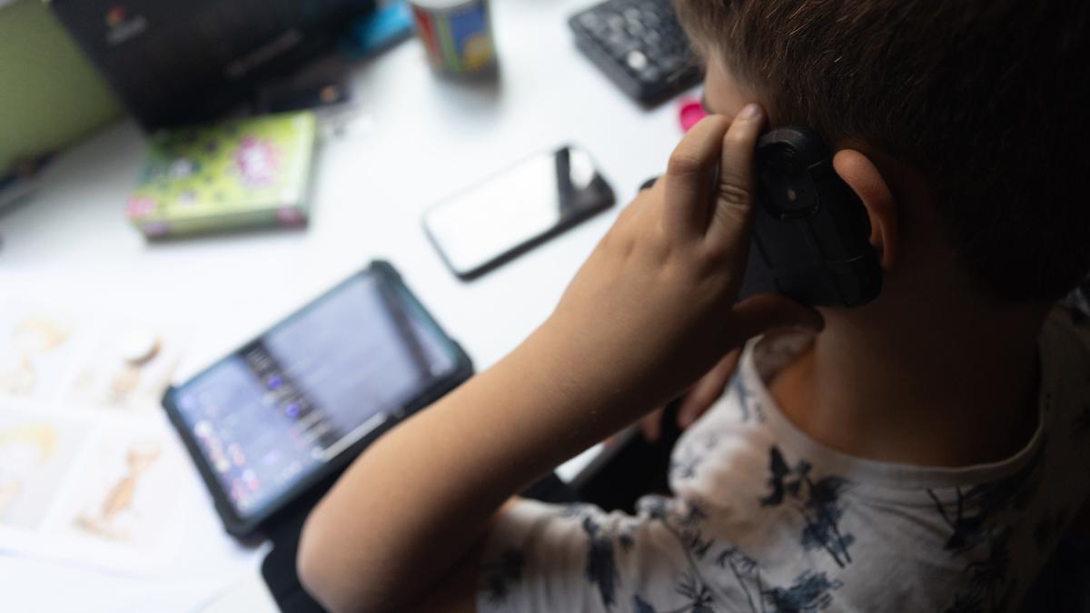 Archivo - Un niño usa el teléfono móvil y una tablet, a 18 de octubre de 2023, en Madrid (España). Según la Vanguardia, en España se estima que el 21% de los adolescentes es adicto a la red y casi la mitad reconoce que tiene &quot;un contacto activo&quot; cada 15 m