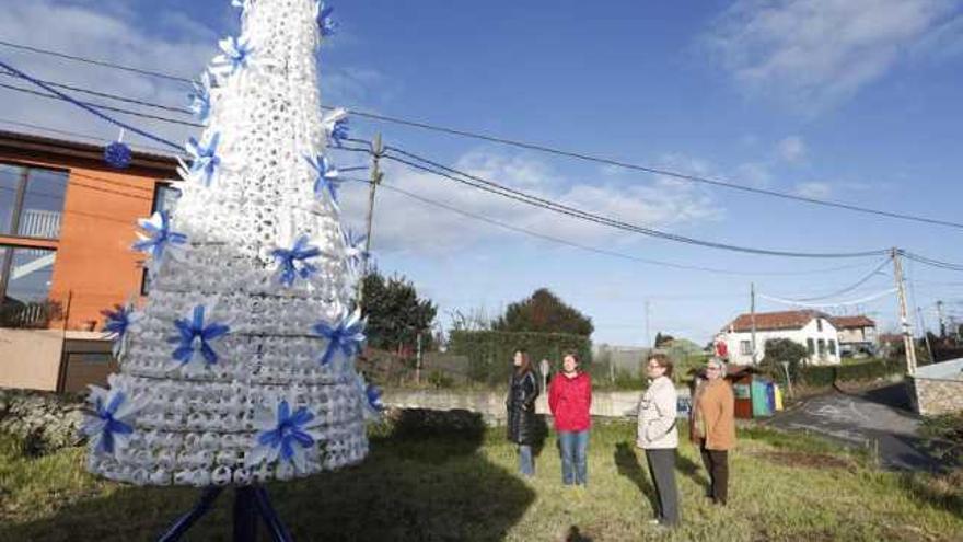 Un grupo de vecinas de San Martín de Laspra junto al árbol de Navidad realizado con plásticos.