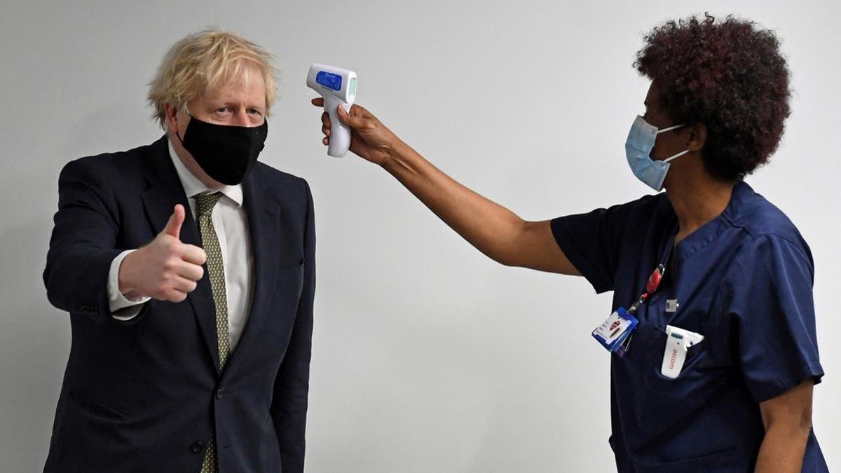 Una mujer toma la temperatura al primer ministro Boris Johnson