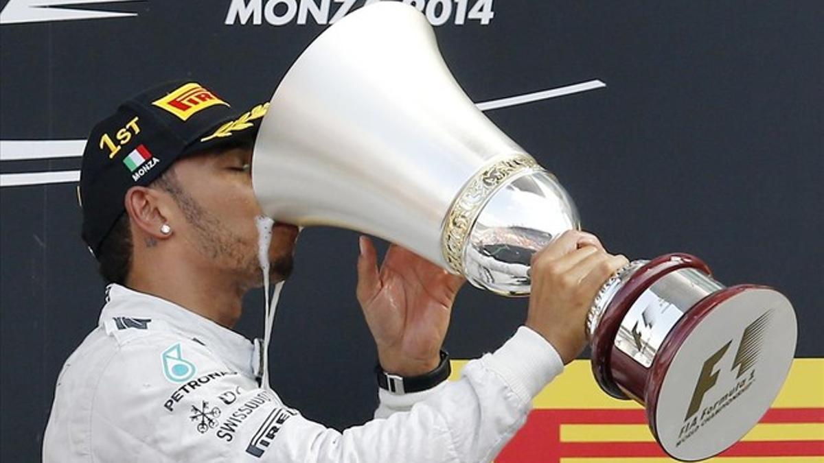 Hamilton bebé champán en el trofeo de campeón del Gran Premio de Italia en el podio del circuito de Monza.
