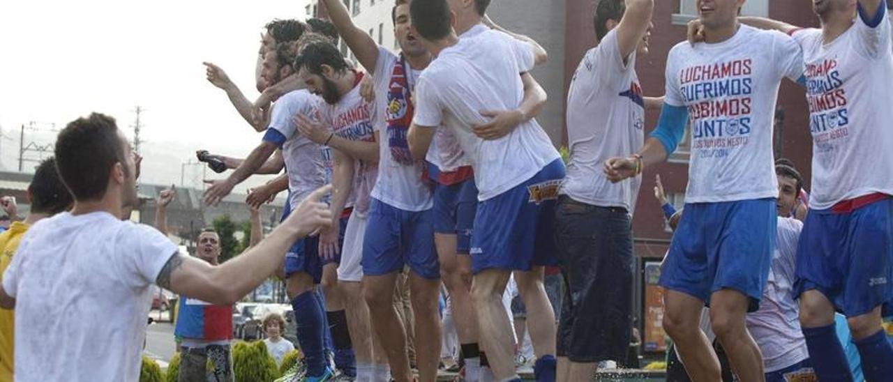 La plantilla se baña en la fuente situada en la rotonda de Langreo Centro.