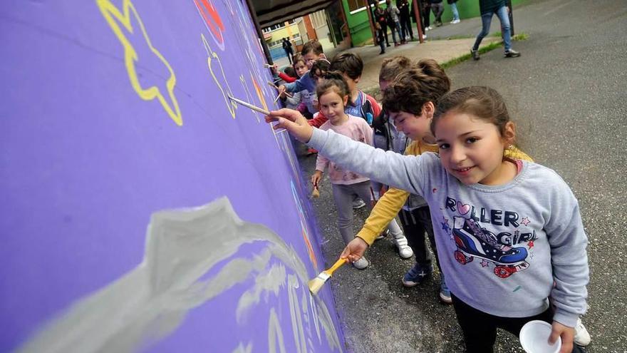 Niños pintando en un muro en el colegio de Morcín ayer al mediodía.