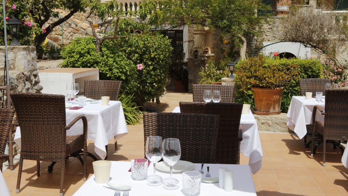 Die idyllische Restaurant-Terrasse des Sa Tafoneta inmitten von Rosensträuchern.