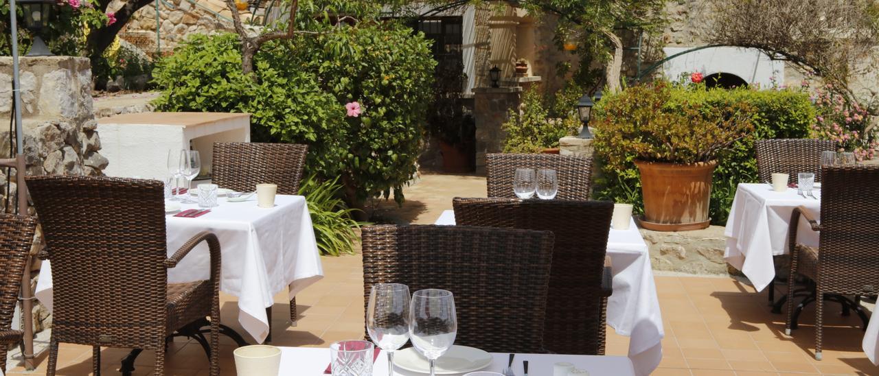 Die idyllische Restaurant-Terrasse des Sa Tafoneta inmitten von Rosensträuchern.