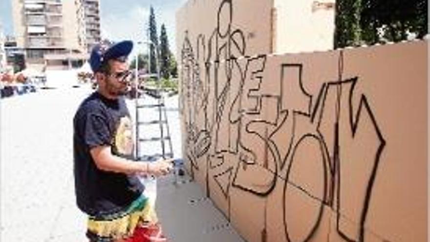 Un dels artistes en plena elaboració d&#039;un grafit ahir al matí.