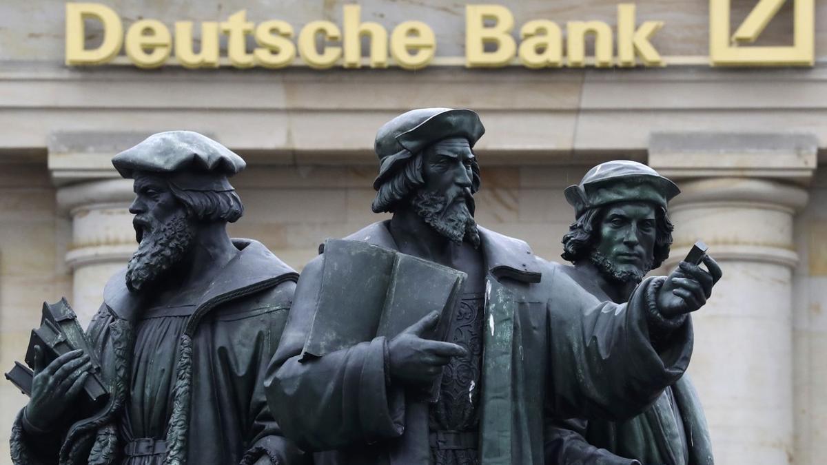 A statue is pictured next to the logo of Germany's Deutsche Bank in Frankfurt