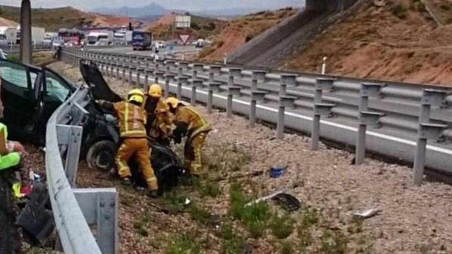 Los bomberos actuando sobre el coche siniestrado