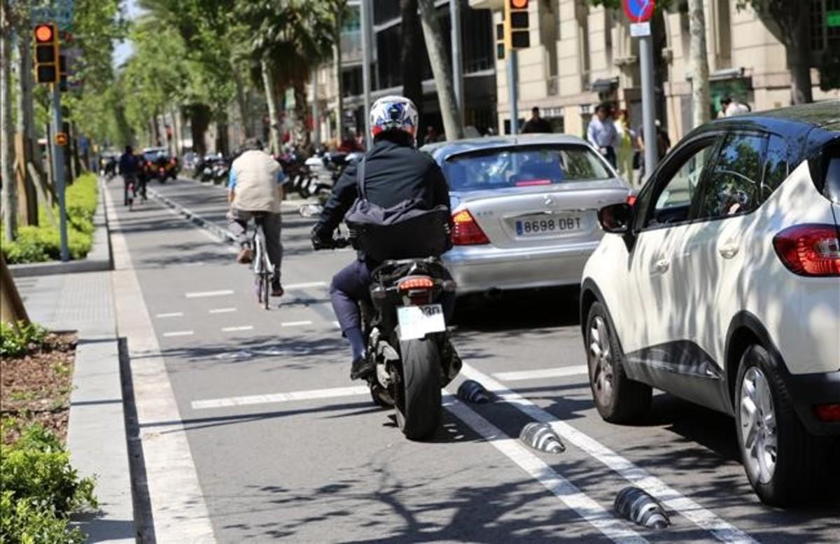 Una moto intenta alcanzar el semáforo por el carril bici. 