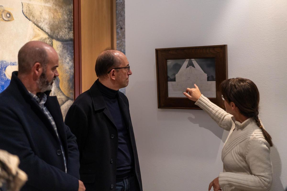 La directora del Museo Massó, Covadonga López, señala un detalle de “A arca de Noé” ante la presencia de Anxo Lorenzo y Félix Juncal.