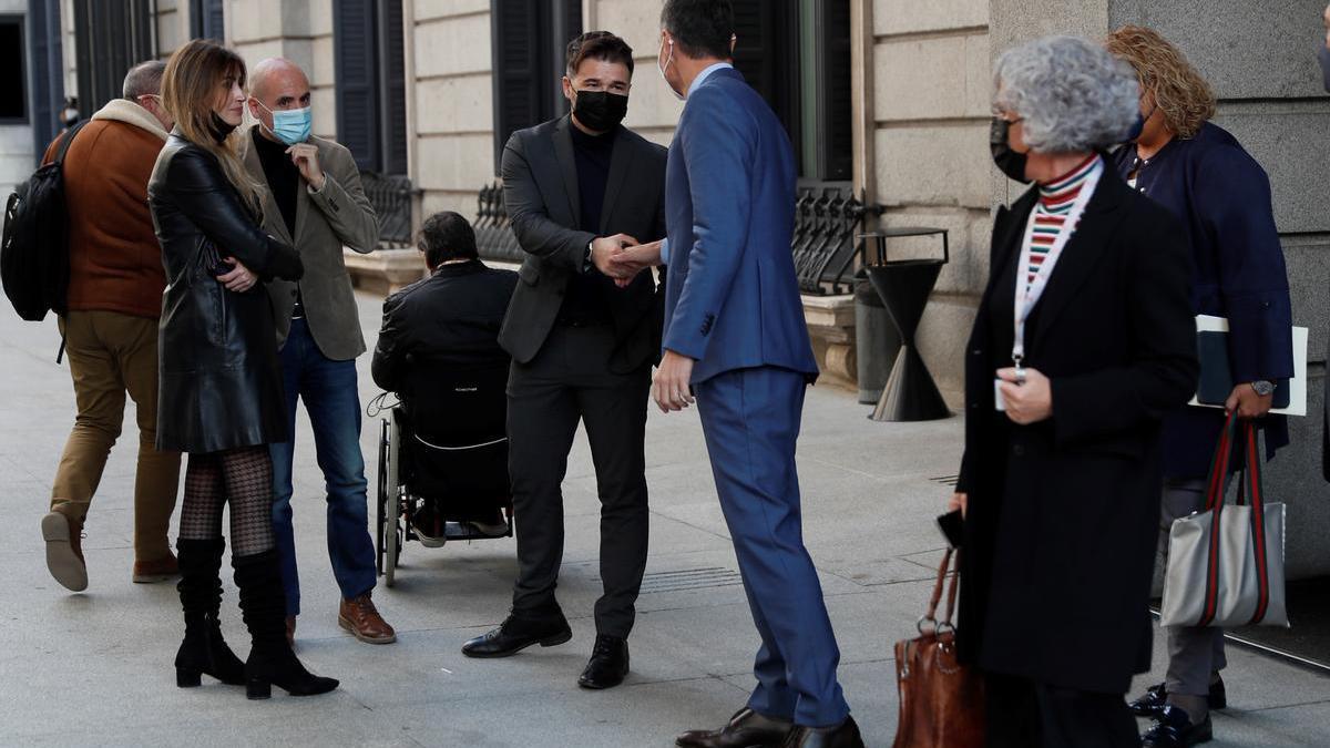 El presidente del Gobierno, Pedro Sánchez, y el portavoz de ERC, Gabriel Rufián, se saludan en el patio del Congreso.