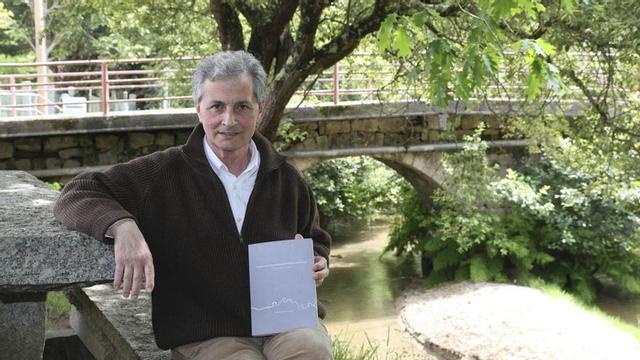 Antonio Soliño, co libro sobre o Camiño da Nosa Señora do Norte, xunto á ponte románica de Mañufe.