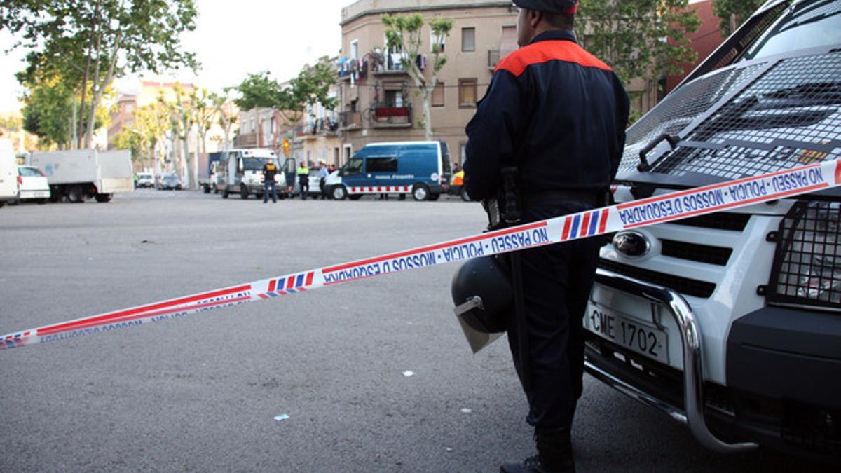 Un agente de los Mossos d'Esquadra vigila la zona donde se ha practicado la redada, en el distrito de Sant Martí, en Barcelona.