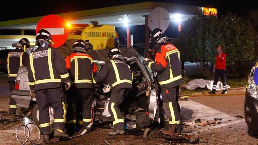 Los bomberos trabajan en uno de los coches involucrados en el siniestro.