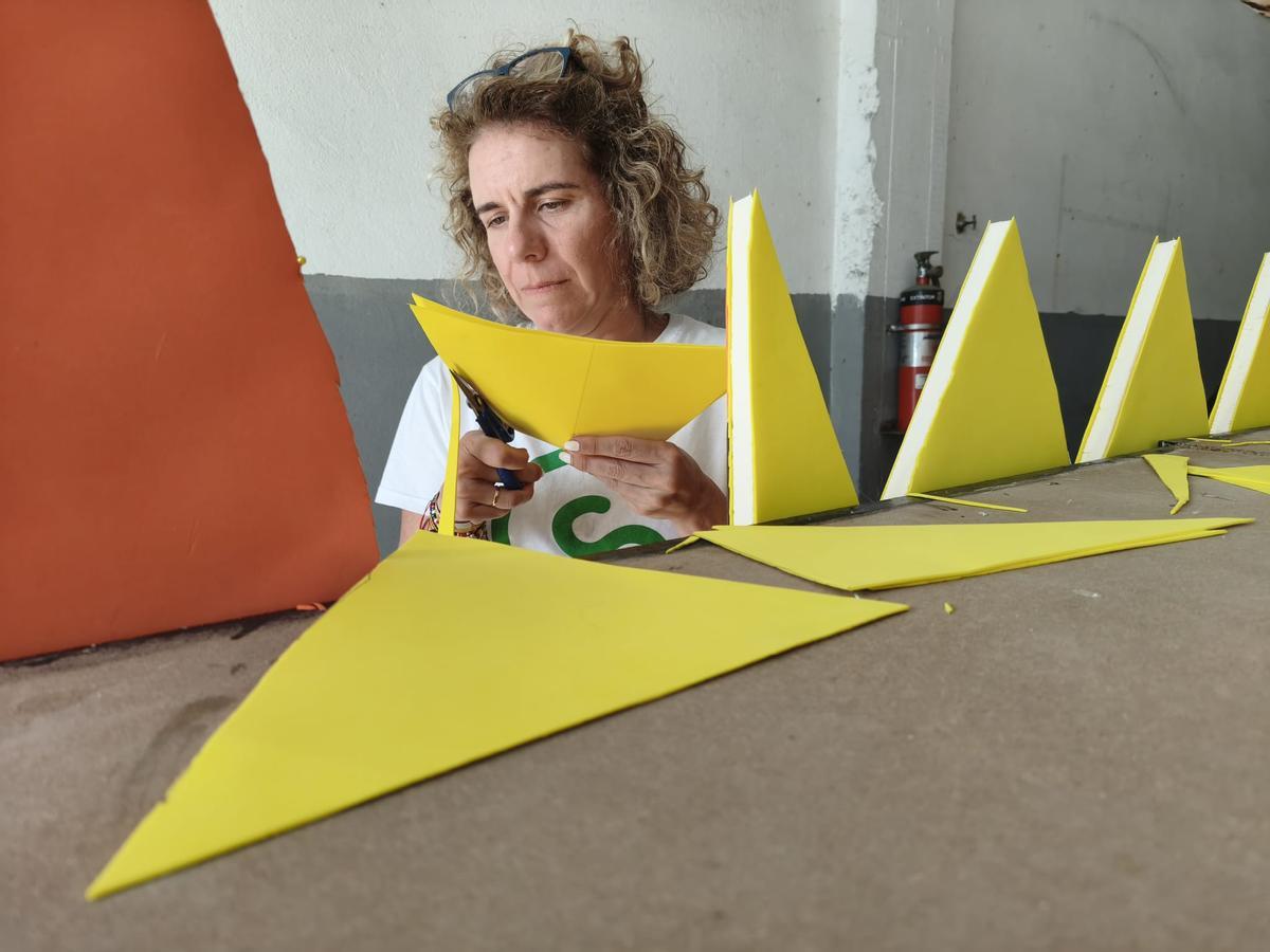 Leticia Sobrino, de la Asociación de Hostelería y Comercio Calle Manuel Pedregal de Grado, prepara una de las decoraciones de la carroza.