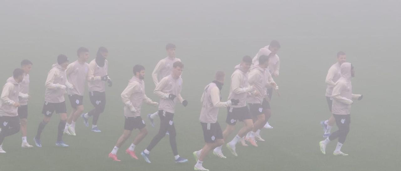 Los jugadores del Celta, envueltos en la niebla durante el entrenamiento de este martes en Afouteza.