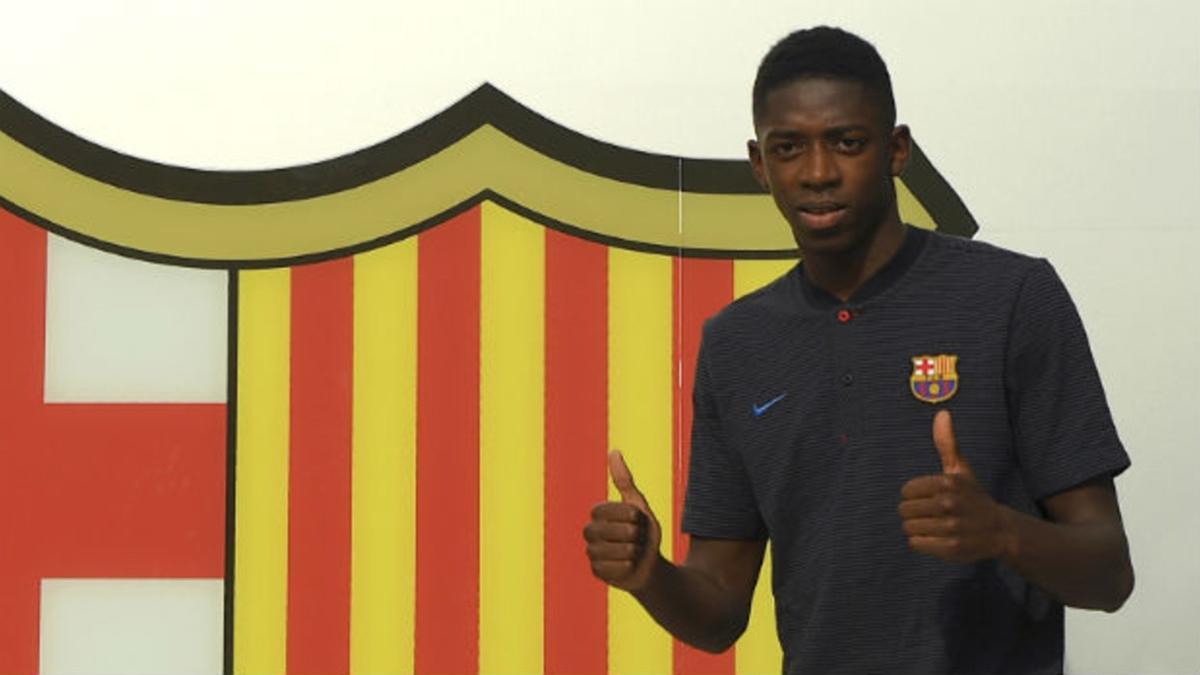 Dembelé posa ante el escudo del Barça en las oficinas del Camp Nou.