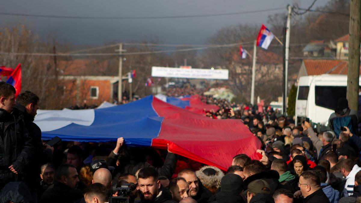 Manifestantes serbokosovares portan una bandera de Serbia gigante en una protesta contra el Gobierno en Rudare, Kosovo.