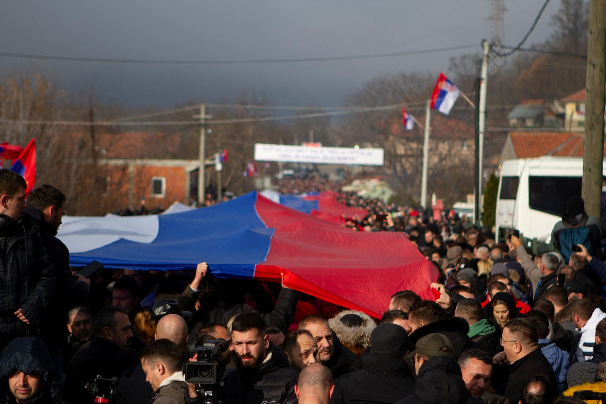 Manifestantes serbokosovares portan una bandera de Serbia gigante en una protesta contra el Gobierno en Rudare, Kosovo.