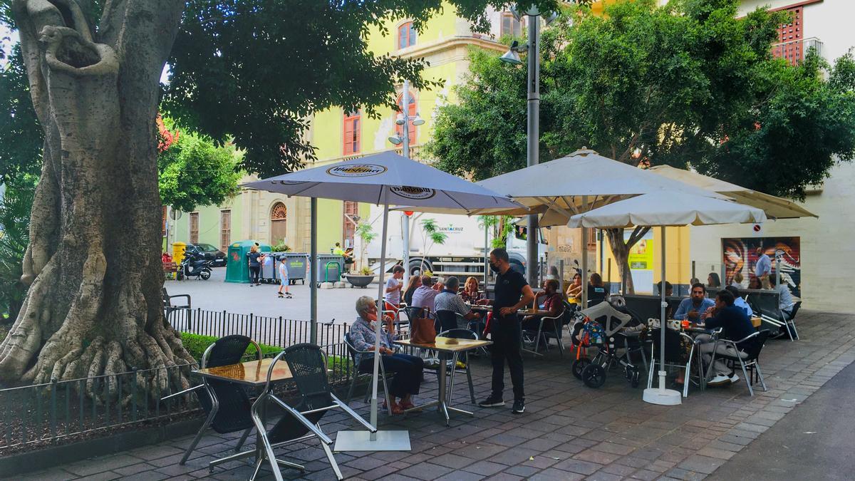 Un trabajador de una terraza de Santa Cruz de Tenerife atiende a uno de sus clientes.