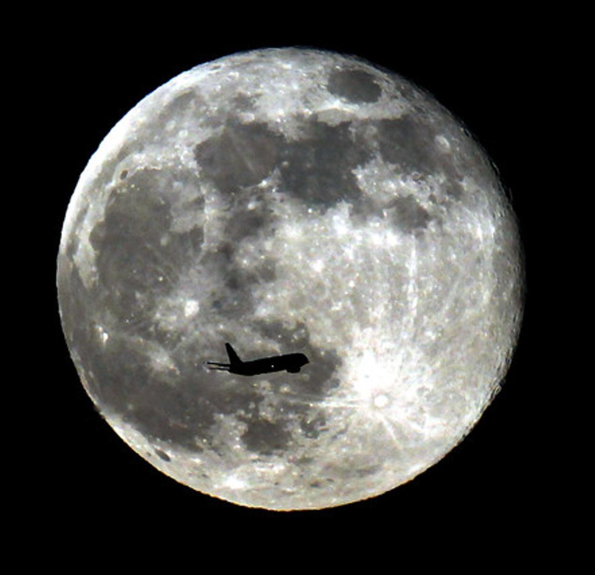 Un avión pasa frente a la ’superluna’ este domingo por la noche en California.
