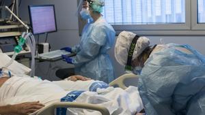 Personal sanitario atiende a un paciente ingresado en la Unidad de Cuidados Intensivos para enfermos de coronavirus del Hospital Josep Trueta de Girona.