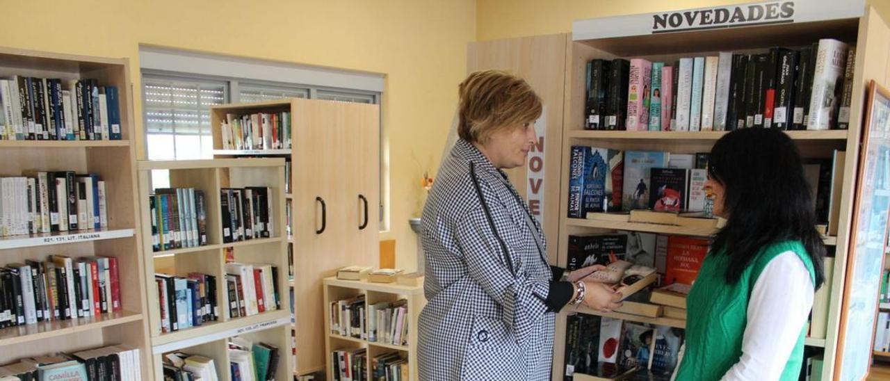 La alcaldesa de Coaña, Rosana González, a la izquierda, y Ana Méndez, en el interior de la biblioteca, en una imagen de archivo. | T. Cascudo