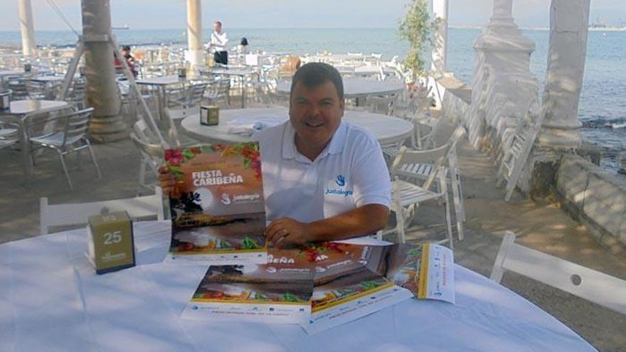 Jesús (Yiyi) Criado, en los Baños del Carmen con el cartel de la fiesta caribeña de la ONG.