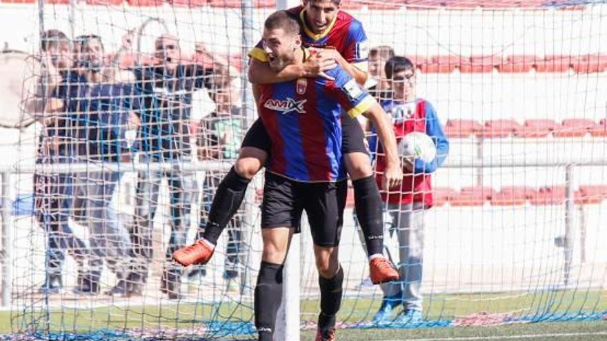 Armero salta sobre el goleador Manu Gavilán celebrando el primero de los dos goles conseguidos por el ariete del Eldense.