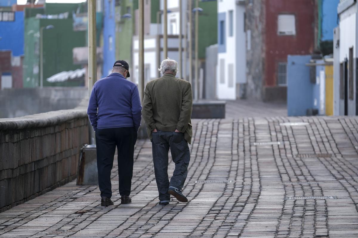 Dos señores caminan por el paseo marítimo de San Cristóbal, en Las Palmas de Gran Canaria.