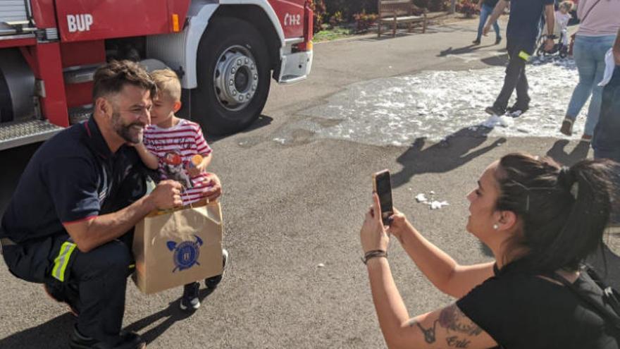 Un bombero abraza a uno de los niños hospitalizados para hacerse una foto.