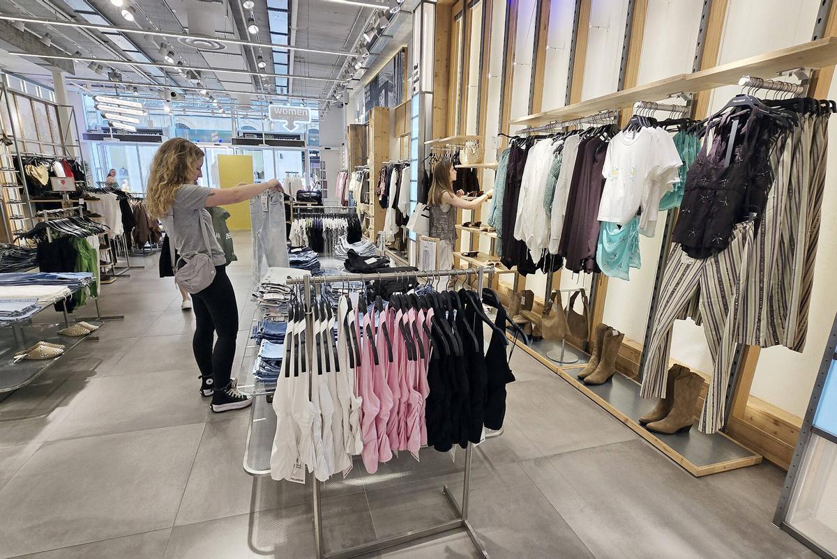 Prendas de colores neutros y sin estampados en diversas tiendas de ropa en Vigo.