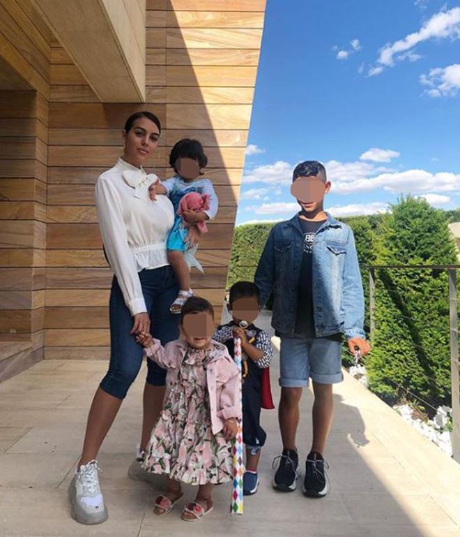 Georgina Rodriguez con sus hijos luciendo una blusa blanca con lazada al cuello