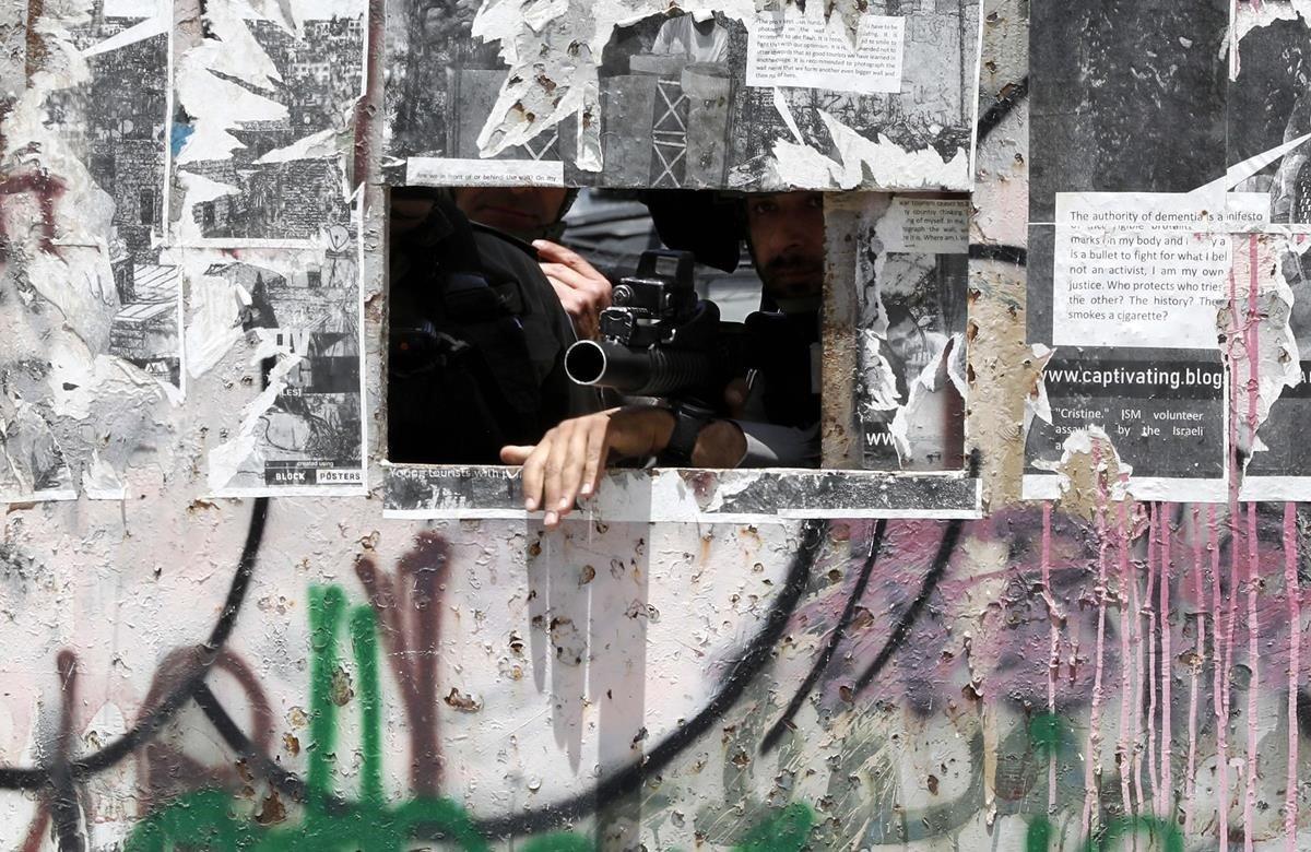 Soldados israelíes vigilan una protesta palestina para conmemorar el 71º aniversario de la Nakba, en la ciudad cisjordana de Belén, este miércoles. Los palestinos conmemoran la Nakba o la Catástrofe, en árabe, que supuso para ellos la creación del Estado de Israel en 1948, con manifestaciones previstas en Gaza en las próximas horas, lo que ha llevado al Ejército israelí a estar en alerta ante posibles episodios de violencia en coincidencia con el festival de Eurovisión.