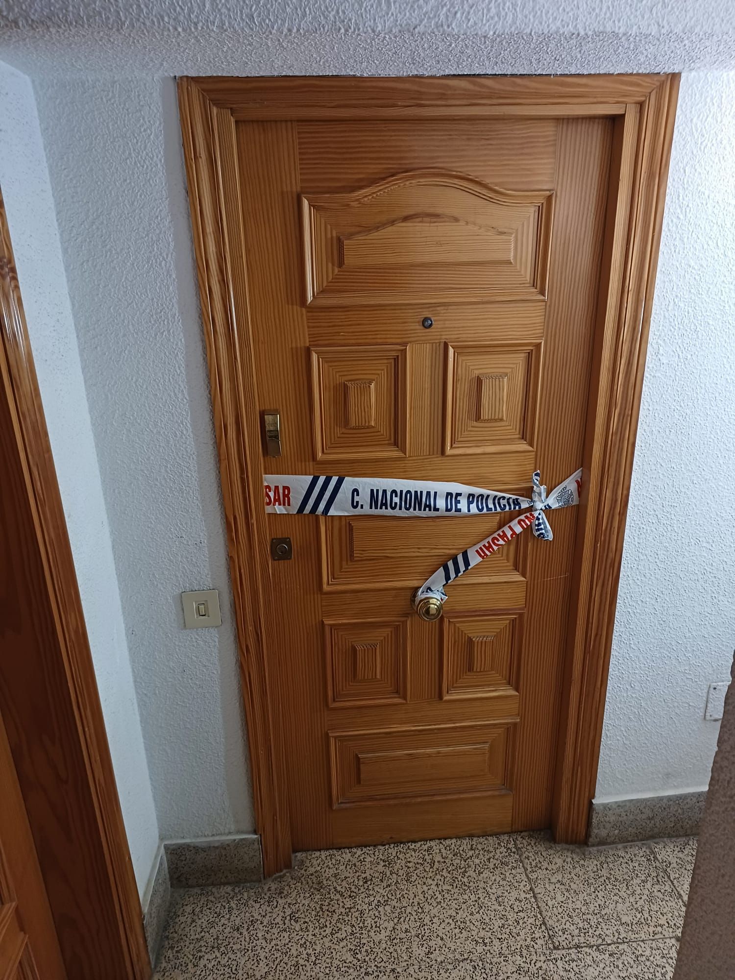 La Policía ha precintado la puerta del domicilio donde han ocurrido los hechos